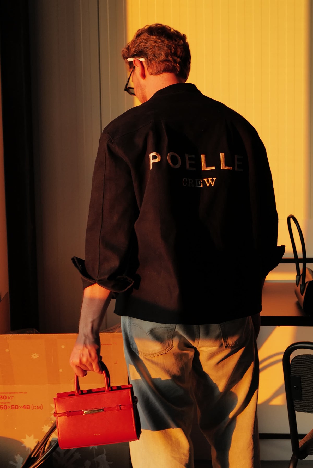 Poelle artisan carrying a bag in the atelier