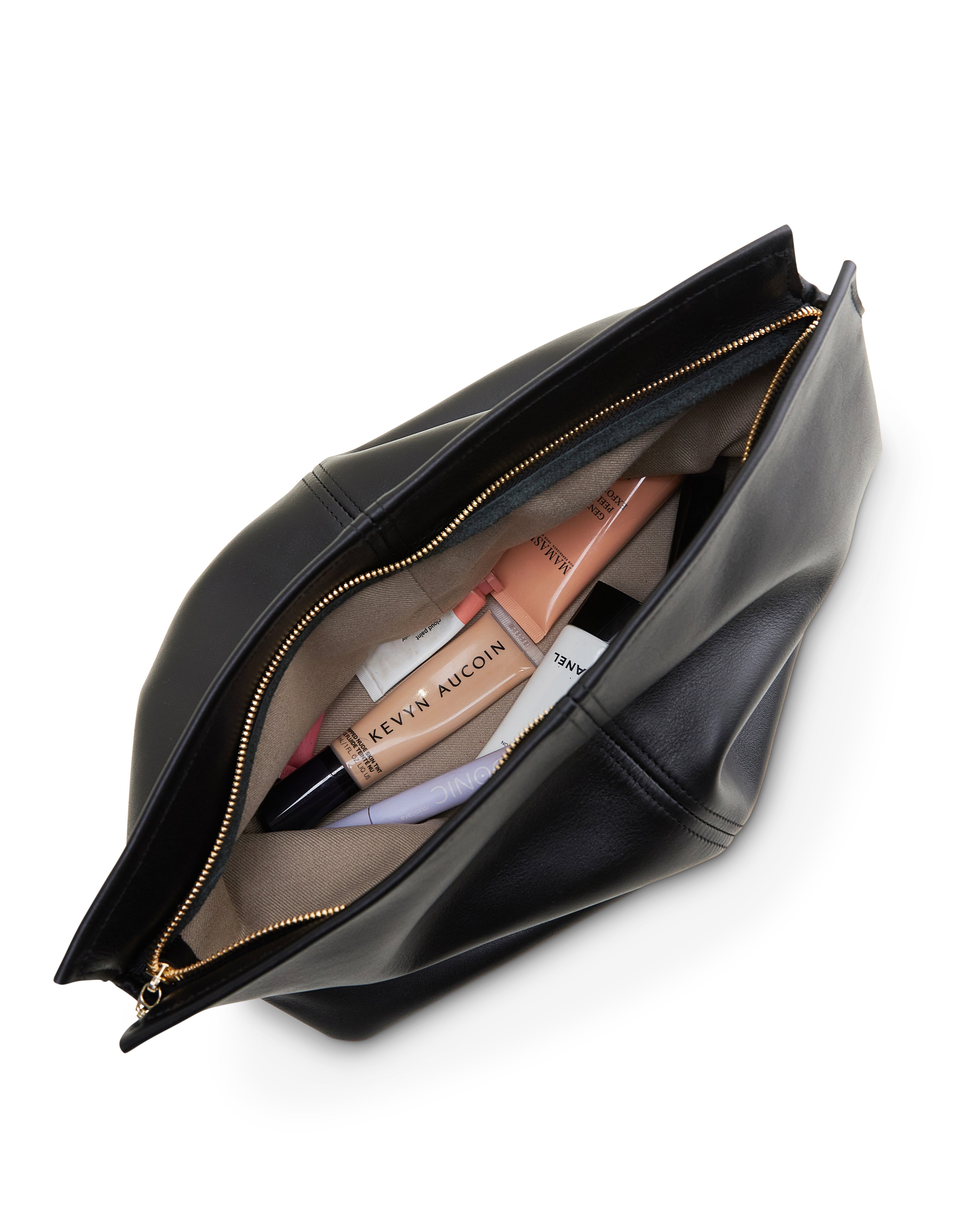 Black luxury leather clutch bag by Poelle Atelier open showing makeup items inside