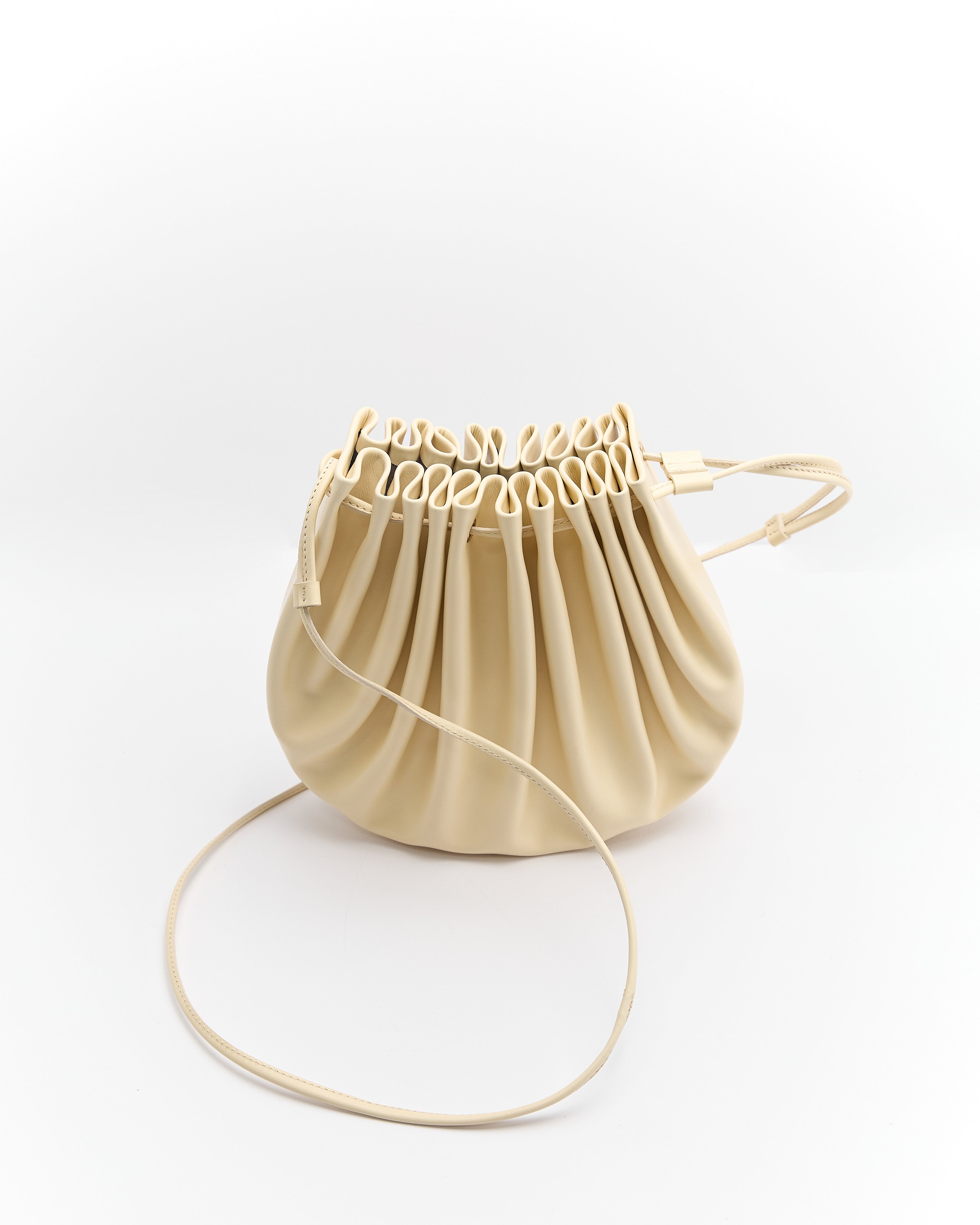 Poelle Atelier luxury summer crossbody bag in beige with ruched detailing and adjustable strap