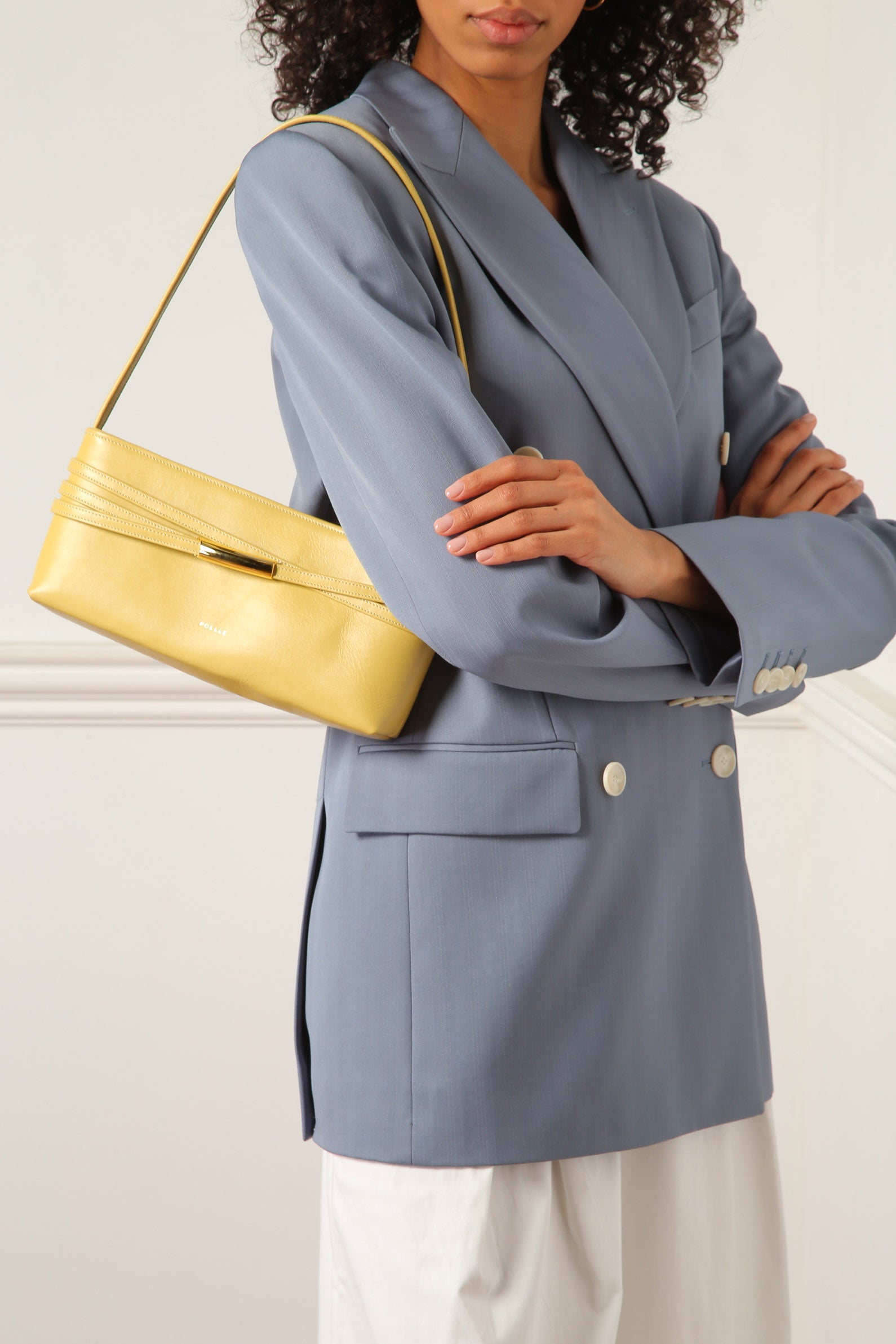 Poelle Atelier modern yellow baguette bag worn with a blue blazer and white pants